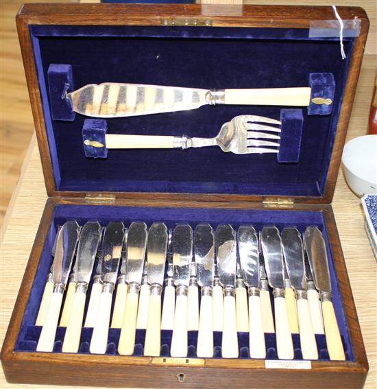 A cased set of twelve pairs of plated fish knives and forks with servers, silver banded ivorine handles